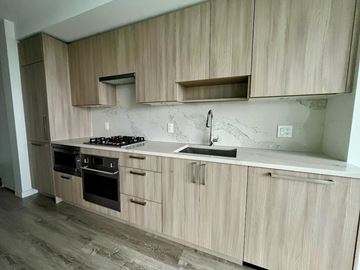 Surrey apartment for rent - A kitchen with wooden cabinets and a marble countertop.