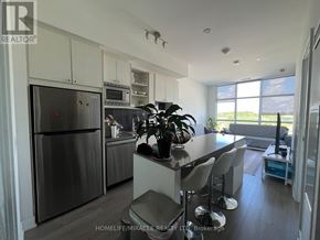 Toronto (Downsview-Roding-Cfb) condo for rent - A modern kitchen with stainless steel appliances and a dining area with a table and chairs.