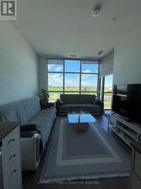Toronto (Downsview-Roding-Cfb) condo for rent - A living room with a grey couch and a television.