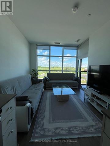 Toronto (Downsview-Roding-Cfb) condo for rent - A living room with a grey couch and a television.