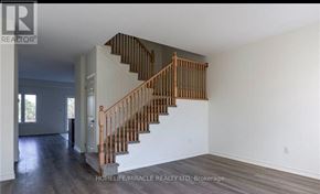 Fort Erie (Crescent Park) townhouse for rent - A wooden staircase with a white wall on one side and a doorway on the other.
