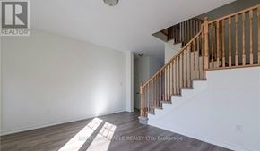 Fort Erie (Crescent Park) townhouse for rent - A room with a staircase and a window letting in sunlight.