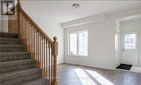 Fort Erie (Crescent Park) townhouse for rent - A spacious room with a staircase leading to the upper floor.
