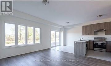 Fort Erie (Crescent Park) townhouse for rent - A spacious kitchen with wooden cabinets and a large island.