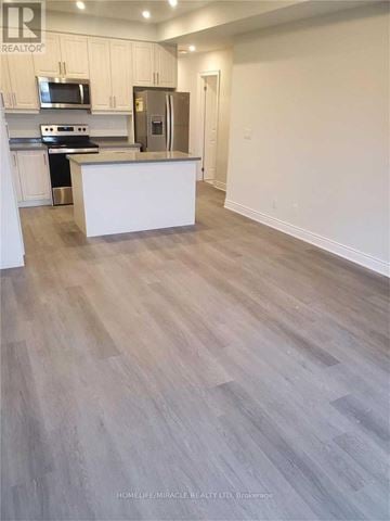 Cambridge townhouse for rent - A kitchen with white cabinets and a wooden floor.