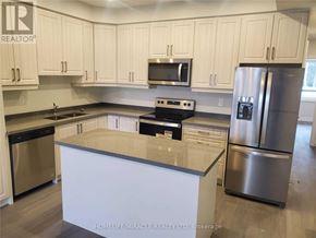 Cambridge townhouse for rent - A kitchen with white cabinets and stainless steel appliances.