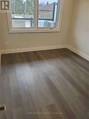 Cambridge townhouse for rent - A room with wooden flooring and a window overlooking a residential area.