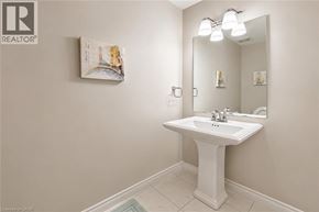 Kitchener townhouse for rent - A white pedestal sink in a bathroom with a mirror and a framed picture on the wall.
