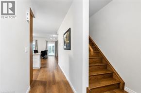 Kitchener townhouse for rent - A hallway with a wooden staircase and a painting on the wall.