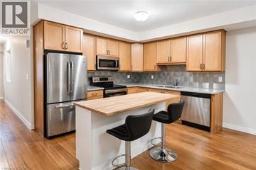 Kitchener townhouse for rent - A kitchen with wooden cabinets and a stainless steel refrigerator.