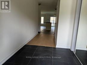 Hamilton (Stoney Creek Mountain) townhouse for rent - A room with a black floor and white walls, with a doorway leading to another room.