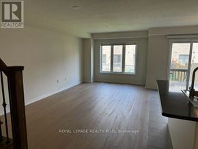 Hamilton (Stoney Creek Mountain) townhouse for rent - A spacious room with wooden floors and a large window.