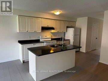Hamilton (Stoney Creek Mountain) townhouse for rent - A kitchen with white cabinets and black countertops.