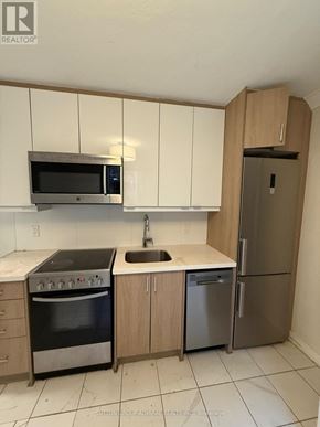 Toronto (Yonge-Eglinton) multi-family for rent - A kitchen with a microwave, oven, sink and refrigerator.