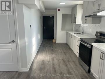 Oshawa (Central) multi-family for rent - A kitchen with a black oven and white cabinets.