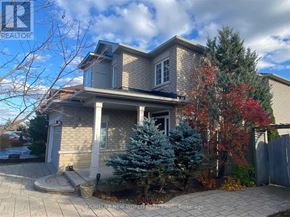 Richmond Hill (Oak Ridges) apartment for rent - A house with a grey roof and a tree with red leaves in front.