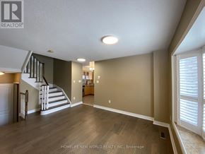 Richmond Hill (Oak Ridges) apartment for rent - A spacious living room with a staircase and a window with blinds.