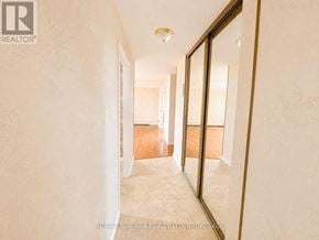Niagara Falls (Stamford) condo for rent - A hallway with a mirror on the wall and a logo that says REALTOR.