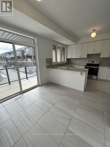 Whitby (Port Whitby) townhouse for rent - A kitchen with white cabinets and a tiled floor.