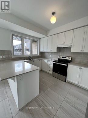 Whitby (Port Whitby) townhouse for rent - A modern kitchen with white cabinets and a stainless steel dishwasher.