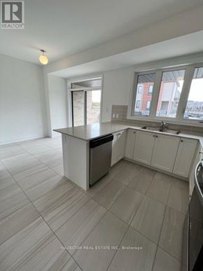 Whitby (Port Whitby) townhouse for rent - A kitchen with a white cabinet system and a stainless steel dishwasher.