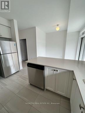 Whitby (Port Whitby) townhouse for rent - A kitchen with a stainless steel refrigerator and a white countertop.