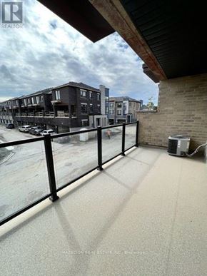 Whitby (Port Whitby) townhouse for rent - A balcony with a glass railing overlooking a parking lot.