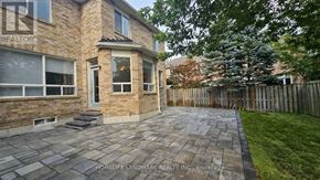 Richmond Hill (Oak Ridges Lake Wilcox) apartment for rent - A stone patio leads to a brick house with a realtor sign.