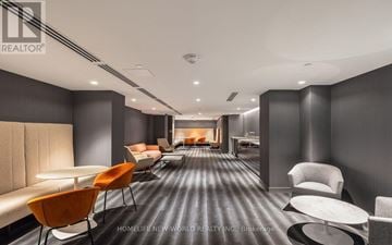 Toronto (Church-Yonge Corridor) condo for rent - A modern living room with a long black carpet and a variety of chairs and sofas.