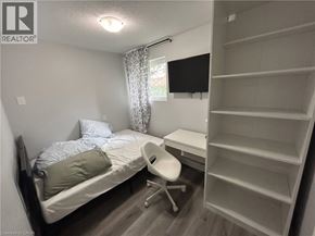 Waterloo apartment for rent - A bedroom with a bed, chair, and shelves.