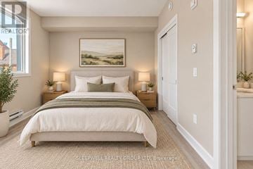 Ottawa multi-family for rent - A well-lit bedroom with a large bed and a painting on the wall.