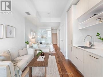 Toronto (Mount Pleasant West) condo for rent - A modern living room with a white couch and a wooden coffee table.