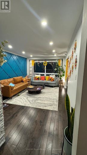 Oshawa (Mclaughlin) apartment for rent - A living room with a couch, coffee table, and a plant.