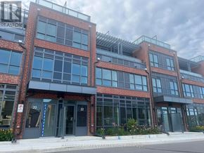 Oshawa (Windfields) townhouse for rent - A multi-story building with a brick facade and large windows.