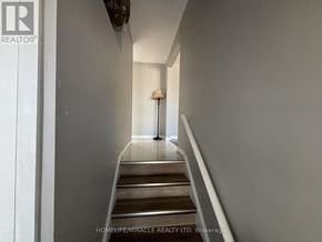 Brampton (Brampton South) apartment for rent - A hallway with a lamp and stairs.