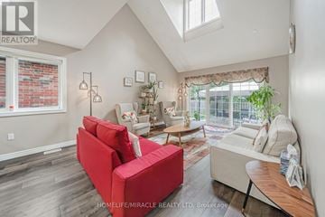 Guelph (Pineridge/Westminster Woods) apartment for rent - A living room with a red couch and a skylight.