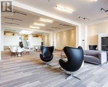 Toronto (Little Portugal) condo for rent - A living room with a grey sofa and black chairs.