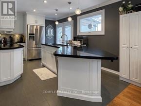 Oshawa (Centennial) apartment for rent - A modern kitchen with a black countertop and stainless steel appliances.