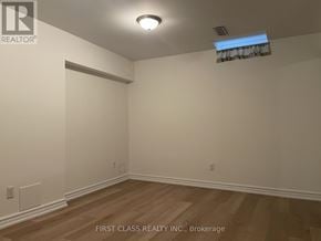 Innisfil (Alcona) apartment for rent - A room with wooden flooring and white walls.