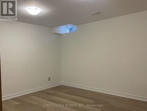 Innisfil (Alcona) apartment for rent - A room with a wooden floor and a light on the ceiling.