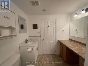 Innisfil (Alcona) apartment for rent - A bathroom with a toilet, sink, mirror, and medicine cabinet.