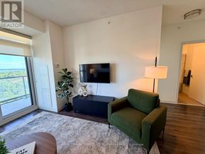 Burlington (Freeman) condo for rent - A living room with a green couch, a flat screen TV, and a sliding glass door.
