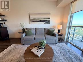 Burlington (Freeman) condo for rent - A living room with a grey couch, a coffee table, and a painting on the wall.