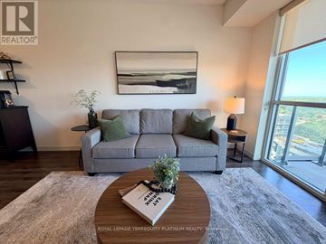 Burlington (Freeman) condo for rent - A living room with a grey couch, a coffee table, and a painting on the wall.