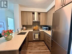 Burlington (Freeman) condo for rent - A kitchen with wooden cabinets and a stainless steel refrigerator.