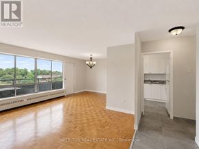 Mississauga (Applewood) condo for rent - A room with a wooden floor and a large window overlooking a cityscape.