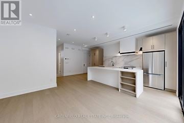 Toronto (Roncesvalles) apartment for rent - A spacious kitchen with white cabinets and a marble island.