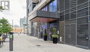 Mississauga (City Centre) condo for rent - A modern building with glass windows and a sign that reads "RE/MAX REALTY SPECIALISTS INC, Brokerage".