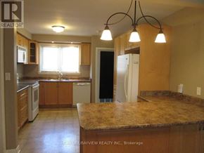 Newmarket (Central Newmarket) apartment for rent - A kitchen with a granite countertop and wooden cabinets.