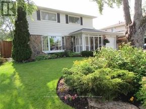 Brampton (Brampton East) apartment for rent - A white house with a well-kept lawn and garden.